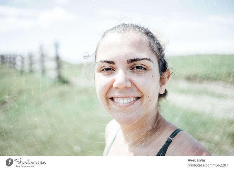 Porträt einer jungen Frau, die nach einer Wanderung in den Bergen direkt in die Kamera lächelt Freiheit Lächeln Person Waffen künstlerisch Atem Atmung brünett