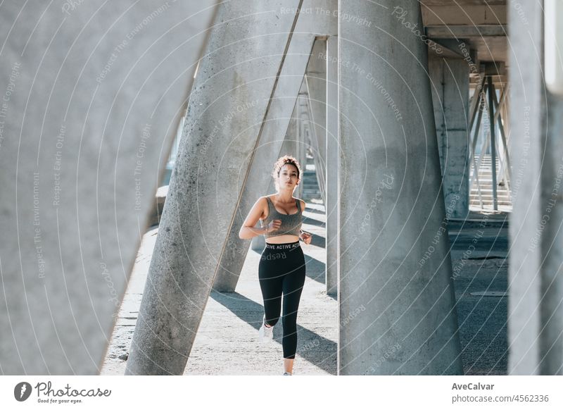 Porträt einer laufenden ernsten jungen afrikanischen arabischen Frau, die nach dem Joggen im Freien lächelt. Direkt in die Kamera, Fitness-Körpertyp. Urban Übung im Freien.