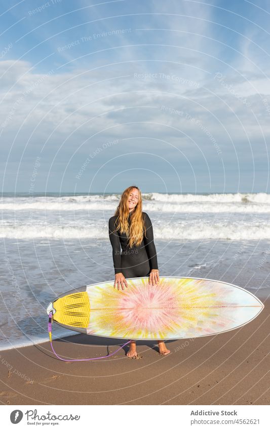 Frau mit Surfbrett am nassen Strand stehend Küste Ufer Lächeln Stehen Hobby Aktivität Zeitvertreib Sport MEER Wasser Gezeiten winken Hafengebiet Seeküste Natur