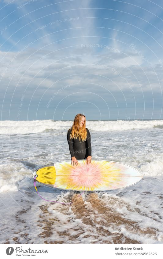 Frau mit Surfbrett am nassen Strand stehend Küste Ufer Lächeln Stehen Hobby Aktivität Zeitvertreib Sport MEER Wasser Gezeiten winken Hafengebiet Seeküste Natur