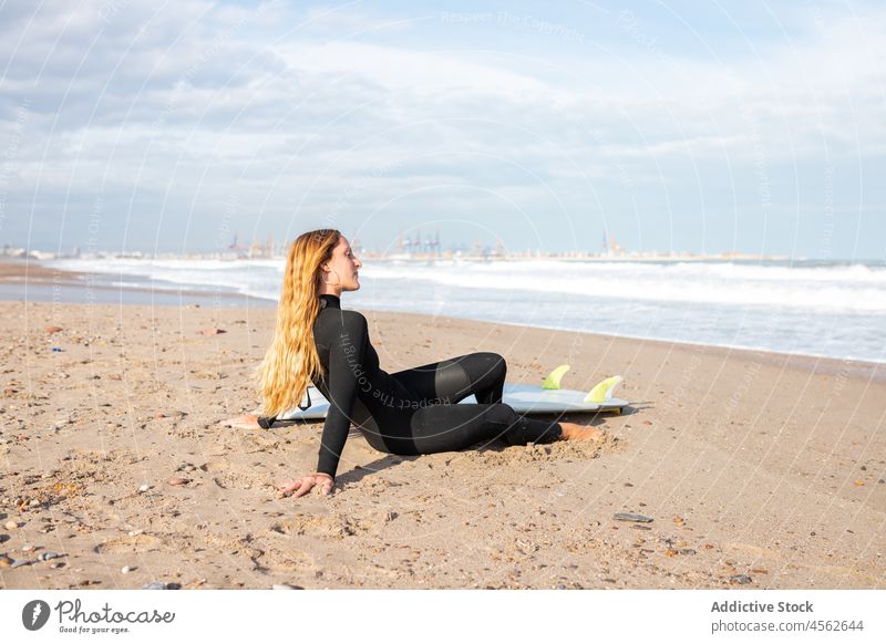 Junge Frau in der Nähe des Surfbretts am Meeresufer Küste Ufer Hobby Aktivität Zeitvertreib Sport MEER Wasser Gezeiten winken Hafengebiet Sand Seeküste Natur