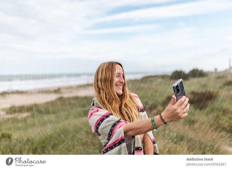 Fröhliche Frau nimmt Selfie in der Natur Smartphone Selbstportrait einfangen Fotografie Zeitvertreib Freizeit Erholung Gras Moment Dame Lächeln Mobile Telefon