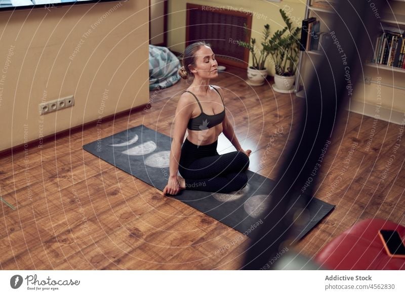 Sportliche Frau bei Schnürsenkel-Asana Schuhbänder Yoga Training Gesunder Lebensstil Übung Wellness üben meditieren Wohnzimmer Wohlbefinden schlank Licht