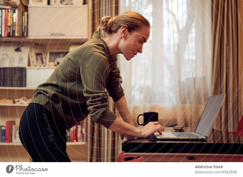 Sportliche Frau mit einem Laptop Training Lifestyle Wellness online Wohlbefinden üben Wohnzimmer schlank Licht Appartement Netbook Gesundheit heimwärts