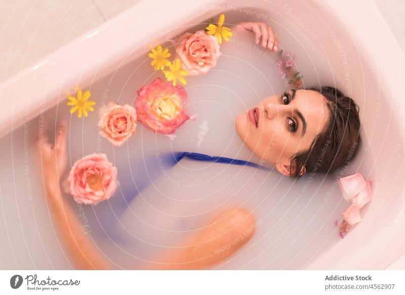 Junge Frau in Milchbad mit Blumen liegend sich[Akk] entspannen Bad Model melken Porträt Badebekleidung Spa Wellness Badeanzug Blüte ruhen Lügen frisch Blütezeit