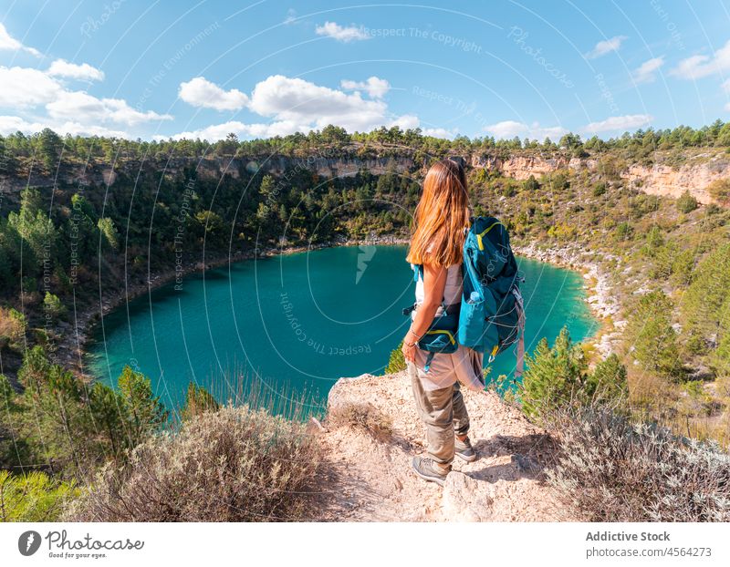 Rucksacktourist bewundert den Blick auf die blaue Lagune Frau Reisender Tourist Wanderer bewundern Klippe malerisch erkunden Trekking Blauer Himmel nachdenken