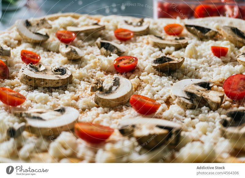 Leckere Pizza mit Champignons und Kirschtomaten Tomate Käse Pilz ungekocht roh Lebensmittel Saucen lecker Mahlzeit Italienisch Bestandteil Gastronomie