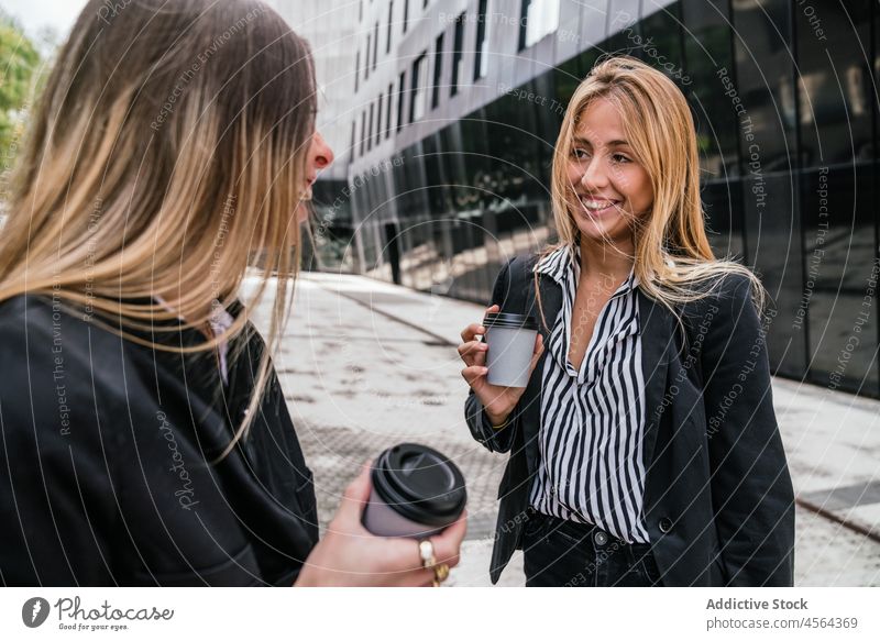 Fröhliche Geschäftsfrauen mit Kaffee zum Mitnehmen auf der Straße Weg Laufsteg Zeit verbringen urban Mitarbeiterin Imbissbude Heißgetränk Getränk Pappbecher
