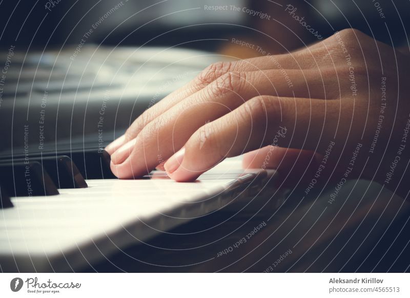 Der Musiker spielt auf dem Klavier. Frauenhände und Tasten in Großaufnahme. Schlüssel Hände Spielen Notizen Zeichenketten schwarze Tasten weiße Tasten