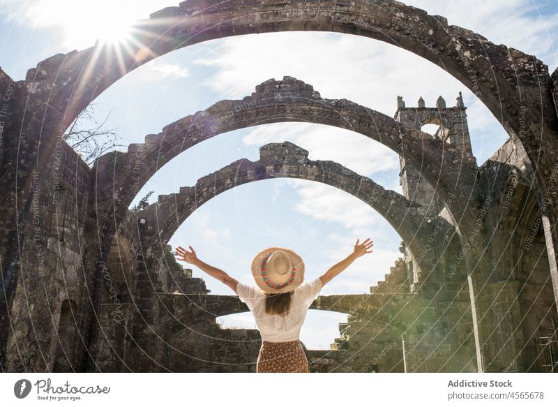 Positive Frau mit Hut, die in einem gewölbten Durchgang die Hand hebt Spanien Bogen Konstruktion santa marina dozo gotisch Kirche Galicia Stein historisch