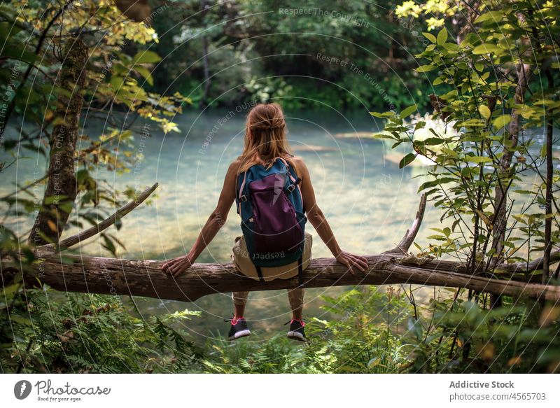 Frau mit Rucksack auf Baumstamm am Seeufer sitzend Spanien bewundern fragas do eume Galicia national Park Natur Abenteuer Fernweh Backpacker Urlaub Kofferraum