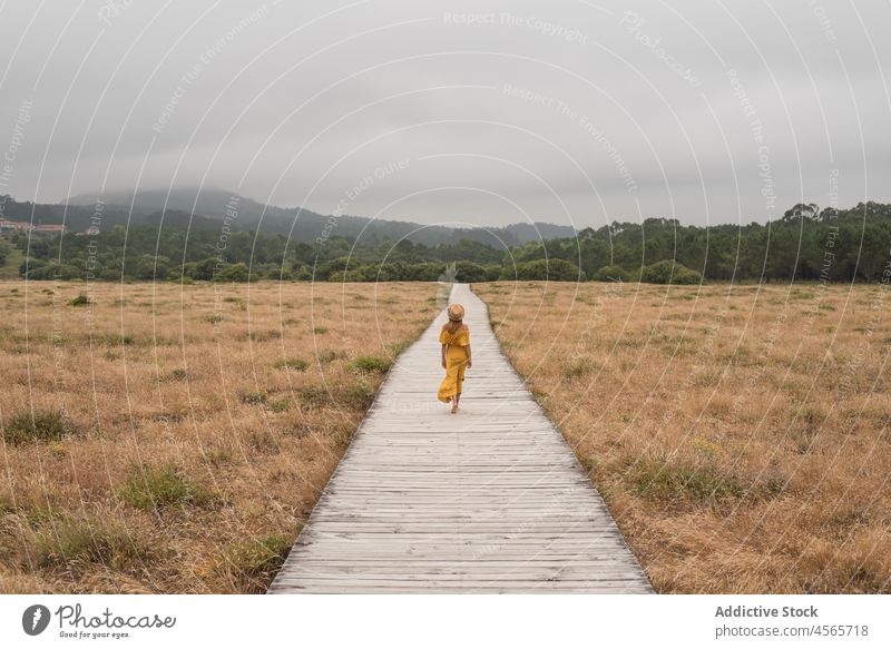 Frau geht auf der Promenade im Grünen spazieren Düne Fußweg Natur Wiese Gras Landschaft corrubedo Galicia Barfuß Weg Spanien hölzern Feld Spaziergang Sommer