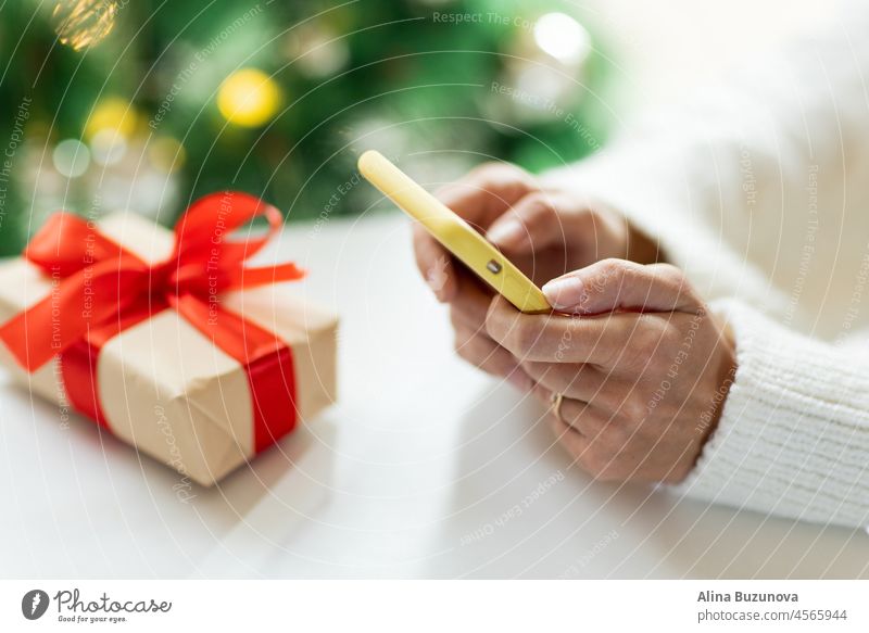 Junge Frau, die während des Weihnachtseinkaufs online bezahlt. Person, die moderne Technologie nutzt. Online-Shopping Weihnachten Neujahr Handy Sale Geschenk