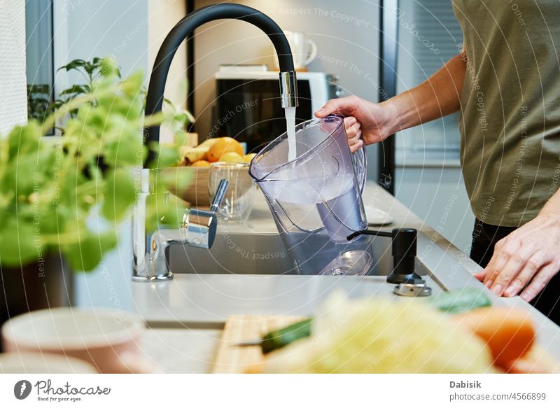 Frau schüttet Wasser aus Filterzacke Wasserhahn Glas Filterung Gießen Lifestyle trinken Küche Gesundheit Tropfen Gesundheitswesen Essen im Innenbereich Osmose