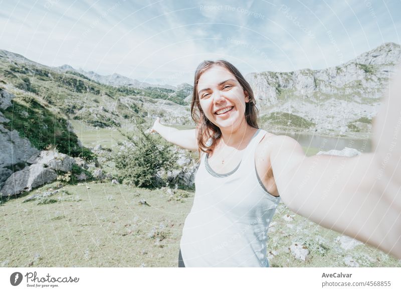 Junge Frau macht ein Selfie in den Bergen nach einem Reisetag. Idyllisches Szenario mit Blick auf die spanischen Berge, die das Leben feiern. Ausruhen nach einem Tag des Wanderns Kopie Raum für hinzufügen