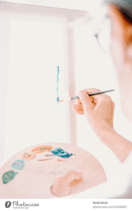 Nahaufnahme von weiblichen älteren alten Künstler Hand, hält Pinsel und Zeichnung Malerei mit blauer Farbe. Bunte, emotionale Ölgemälde. Zeitgenössische Maler Erstellen moderne abstrakte Stück der schönen Kunst