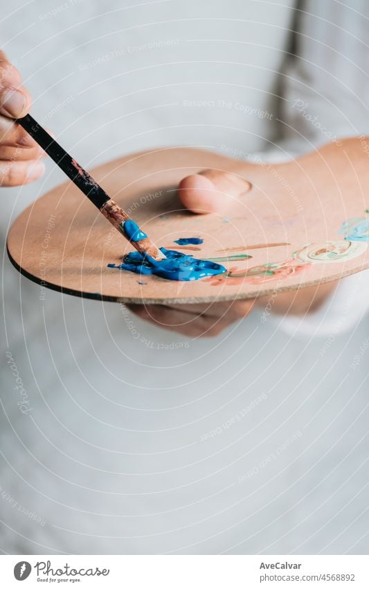 Nahaufnahme von weiblichen älteren alten Künstler Hand, hält Pinsel und Zeichnung Malerei mit blauer Farbe. Bunte, emotionale Ölgemälde. Zeitgenössische Maler Erstellen moderne abstrakte Stück der schönen Kunst