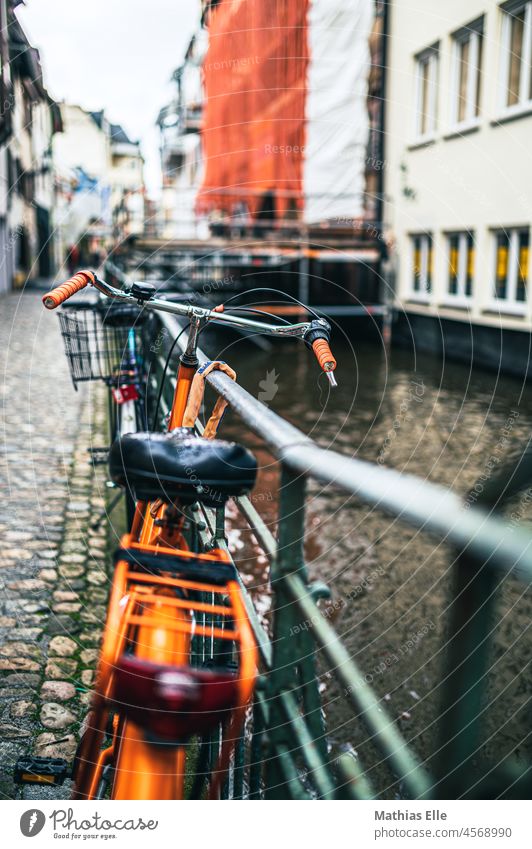 Oranges Fahrrad am Geländer Stadt Außenaufnahme Eisen Stillleben Gepäckträger Radfahrer Schwache Tiefenschärfe Mobilitätskonzept Zaun Tag Stein Amsterdam