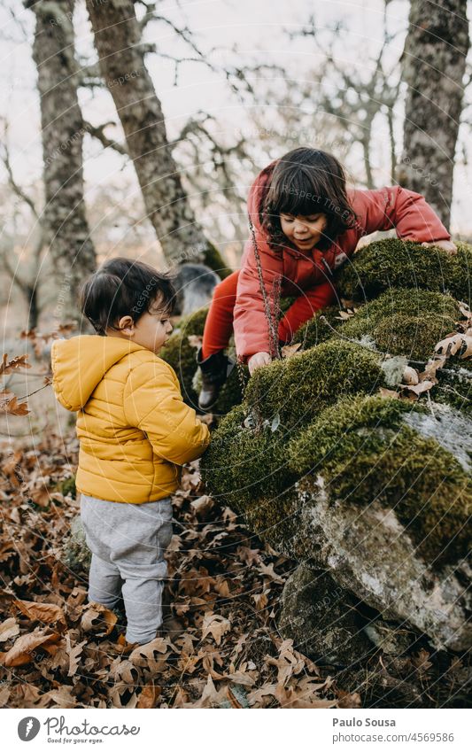 Bruder und Schwester spielen im Wald Kind Kindheit Geschwister Kaukasier 1-3 Jahre 3-8 Jahre Junge Mädchen authentisch Winter Herbst herbstlich Kapuze gelb