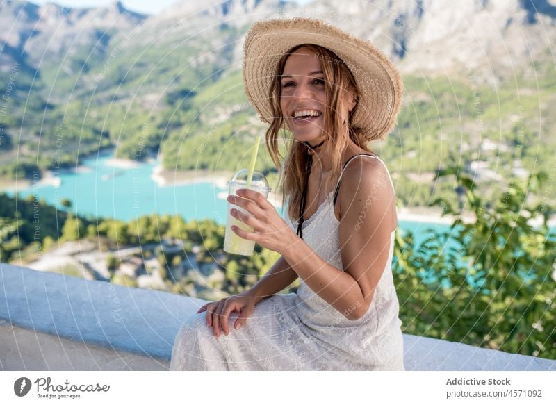 Fröhliche reisende Frau genießt ein erfrischendes Getränk in einem Tal Reisender Berge u. Gebirge See Wasser Erfrischung trinken Saft Erholung Natur