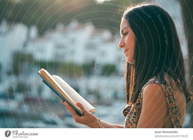 junge Frau liest bei Sonnenuntergang auf ihrer Terrasse ein Buch hübsch lesen sich[Akk] entspannen Erholung Bildung außerhalb allein Lernen Literatur Schüler