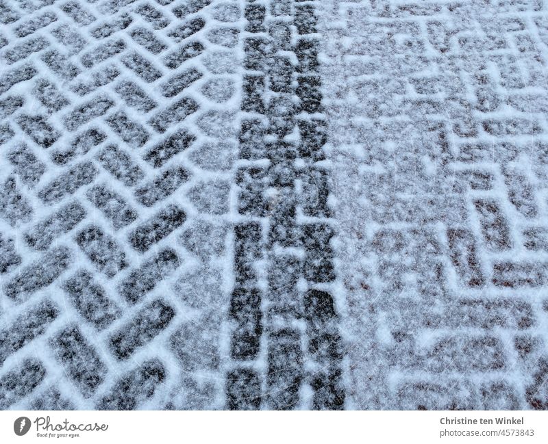 leicht verschneit sind die in unterschiedlichem Muster verlegten Pflastersteine Winter Glätte Textur Strukturen & Formen Schnee Hintergrundbild Stein Straße