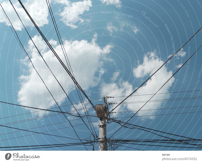 Straßenlampe und Strompfosten in einem gegen hohen Himmel mit Wolken im Sommer elektrische Leitung Energie Verbindung Anschluss high sky Natur vs Technik
