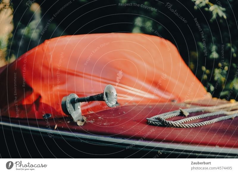 Rotes kleines Motorboot mit Signalhorn unter Plane rot Hupe Seil Tau abgestellt sonnig Boot Wasserfahrzeug Sportboot Winterlager warm Spätsommer Linie