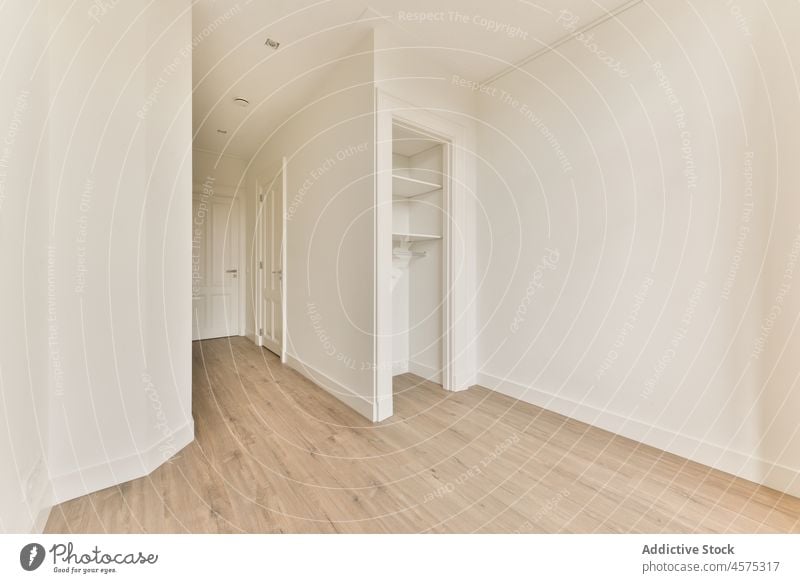 Leeres Zimmer mit weiß getünchten Wänden und eingebautem Kleiderschrank geräumig Raum Innenbereich Zimmerdecke Design leer Licht sehr wenige einfach modern