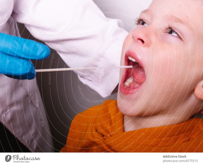 Krankenschwester nimmt Speichelprobe eines Jungen Krankenpfleger geduldig Tupfer Prüfung Coronavirus Probe Krankenhaus Pandemie Medizin Infektion Kind Klinik