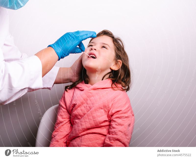 Krankenschwester nimmt Speichelprobe eines Mädchens Krankenpfleger geduldig Tupfer Prüfung Coronavirus Probe Krankenhaus Pandemie Medizin Infektion Kind Klinik