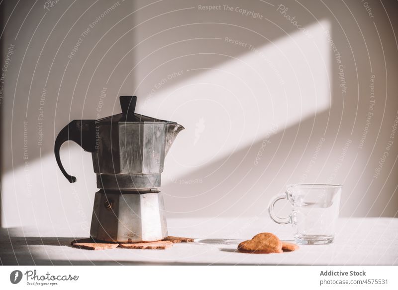 Geysir-Kaffeemaschine mit Tasse und Keksen auf dem Tisch Moka-Topf Dessert lecker Frühstück Gebäck brauen trinken Form Glas Metall Herz Morgen Sonnenlicht Küche