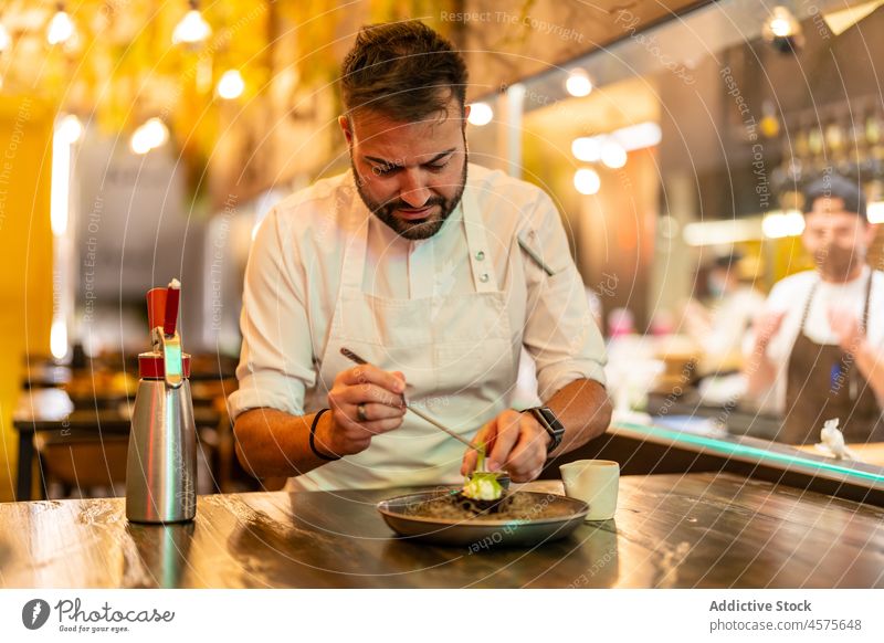 Chefkoch serviert Teller mit Seeigel in einem Restaurant der Haute Cuisine Mann Küchenchef dienen Gastronomie vorbereiten Bestandteil Feinschmecker Job männlich