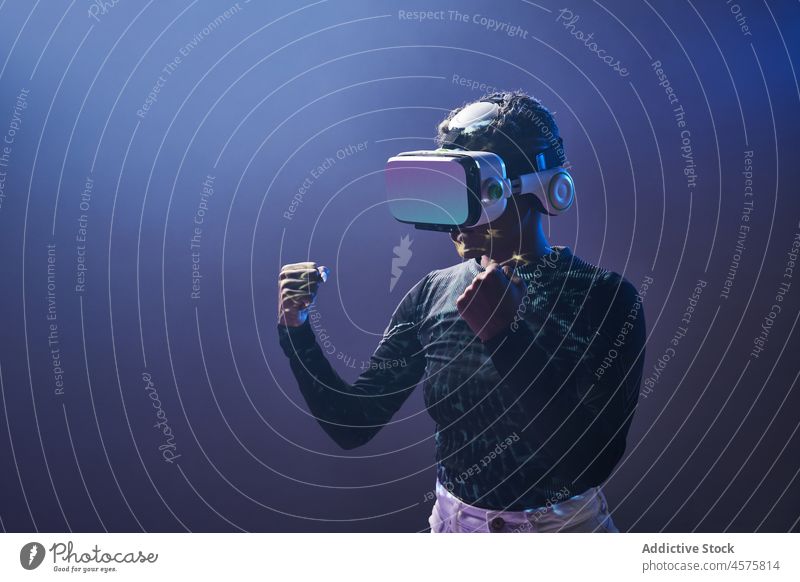 Schwarze Frau mit VR-Brille und geballten Fäusten Boxsport Headset Spiel Virtuelle Realität kämpfen Schutzbrille Cyberspace futuristisch Hallo Technik