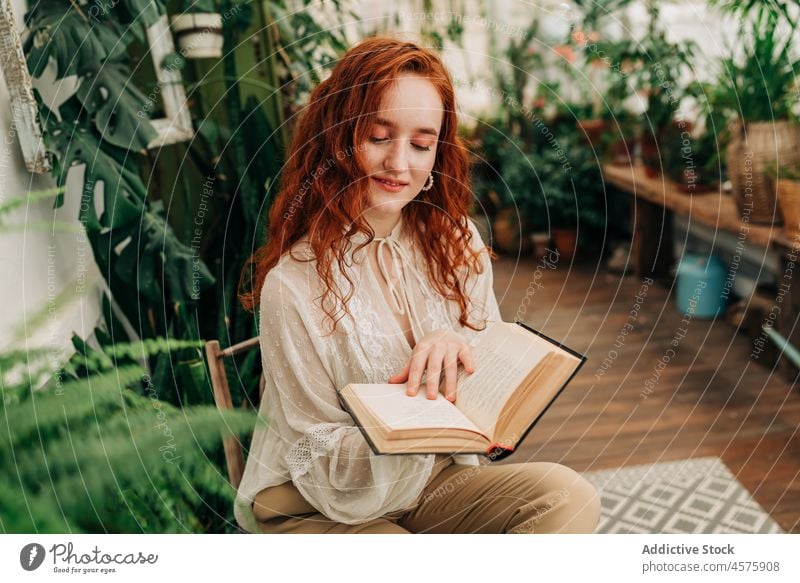 Junge Frau liest ein Buch zwischen Topfpflanzen lesen Literatur Freizeit Zeitvertreib Hobby Garten Pflanze Botanik Blumentopf Roman Konzentration Fokus