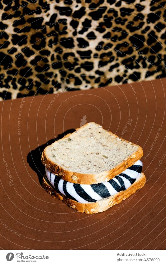 Gesichtslose Person in der Nähe eines Sandwichs mit Zebrafüllung Belegtes Brot Tier schädlich Ökologie unfreundlich vernichten Problematik Annihilation