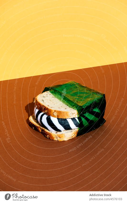 Sandwich in grüner Frischhaltefolie Belegtes Brot verschmutzen Kunststoff umhüllen Zebra Tier schädlich Ökologie unfreundlich vernichten Lebensmittel Licht
