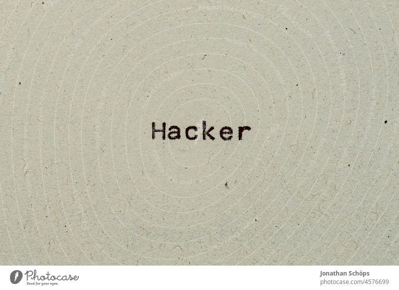 Hacker als Text auf Papier mit Schreibmaschine Computerhacker Cyberkriminalität Recycling Schrift Typografie analog hacken retro text textfreiraum vintage