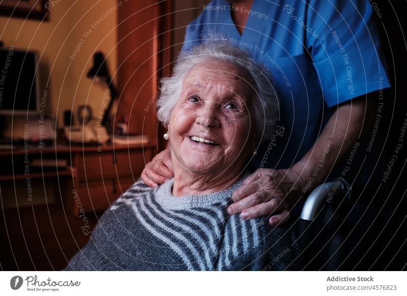 Anonyme Krankenschwester mit behinderter älterer Frau Krankenpfleger gealtert geduldig Hilfsbereitschaft Pflege Rollstuhl Fenster abstützen Rentnerin Spezialist