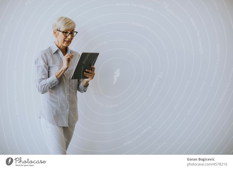 Ältere Frau benutzt digitales Tablet im Büro Tablette Unterlage Geschäftsfrau Arbeit Senior Internet Business Technik & Technologie Karriere reif professionell