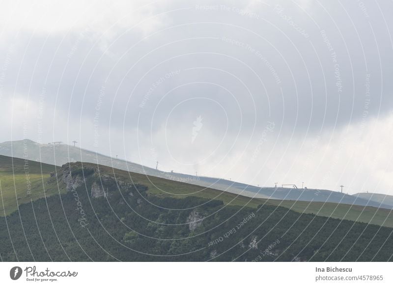 Eine Gondel Bahn Linie am Horizont, entlang einer Bergsteigung. Seile mast Außenaufnahme berg Himmel Ferien & Urlaub & Reisen Wolken Farbfoto Natur