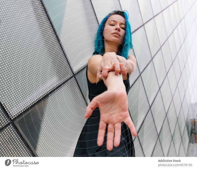 Selbstbewusste Frau tanzt an der Wand eines modernen Gebäudes Tanzen Hobby ausführen Choreographie Porträt charmant Tänzer Vorschein trendy Stil Straße froh