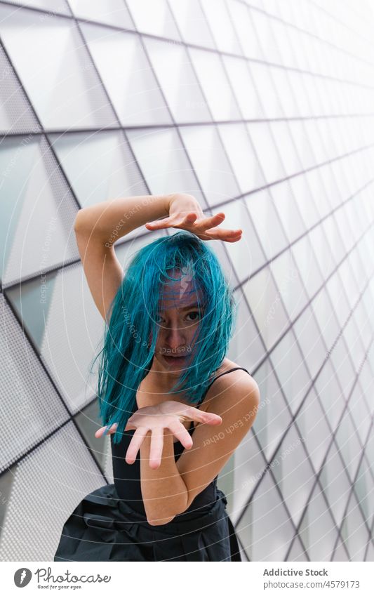 Selbstbewusste Frau tanzt an der Wand eines modernen Gebäudes Tanzen Hobby ausführen Choreographie charmant Porträt Arme hochgezogen Tänzer Vorschein trendy
