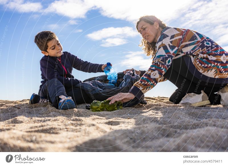 Mutter und Sohn sammeln Plastik und Müll am Strand auf Flasche Pflege Kaukasier Kind Sauberkeit Säuberung Küste abholen sammelnd dreckig Ökologie Umwelt