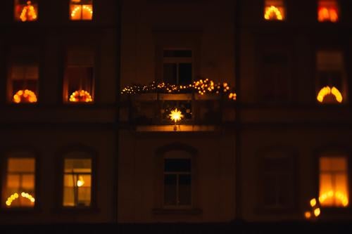 Weihnachtsbeleuchtung an einem Mehrfamilienhaus in den Fenstern Lichterkette Weihnachten & Advent draußen dunkel abend leuchten Beleuchtung Deko