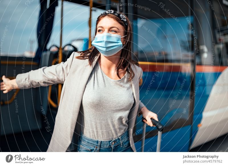 Junge Frau mit Schutzmaske auf Reisen im Bus reisen Mundschutz Passagier Ausfahrt lassen Transport Gepäck Portugal Faro Glück Tasche Geschäftsfrau covid-19