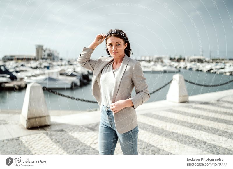 Porträt einer jungen Frau, die am Jachthafen am Atlantischen Ozean spazieren geht Mädchen Glück Tourist Meer MEER Wasser Spaziergang Jeanshose Briten braun