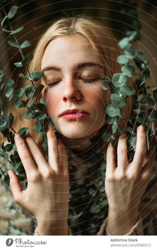 Junge Frau mit grünen Eukalyptuszweigen im Gesicht gestrickt Pullover Zweig frisch Pflanze Porträt Ast blond sanft Windstille filigran Harmonie organisch