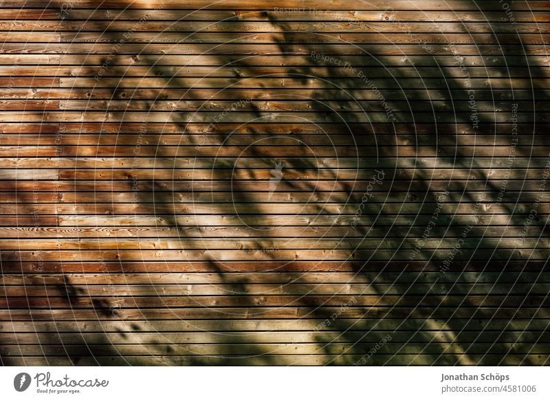 braune Holztextur von Holzhaus Wand gleichmäßig mit Schattenspiel Menschenleer Abnutzung Außenaufnahme Hintergrundbild Oberflächenstruktur flach Muster einfach