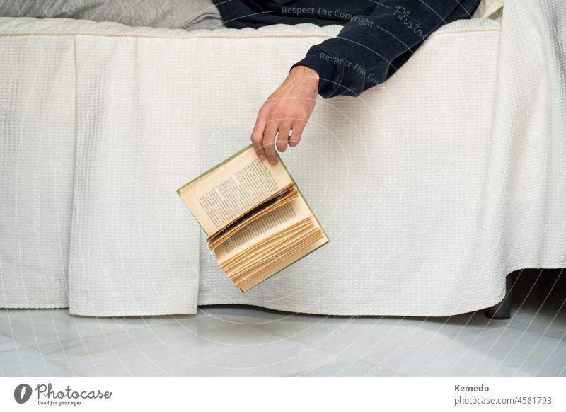 Person schläft beim Lesen eines Buches ein, Konzept der Langeweile zu Hause. Konzept der Langeweile zu Hause mit Kopie Raum. Bohrung schlafend lesen Bett